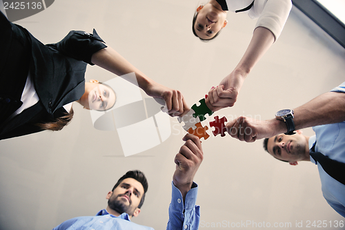 Image of Group of business people assembling jigsaw puzzle