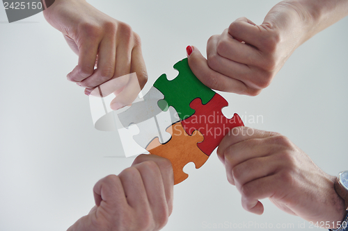 Image of Group of business people assembling jigsaw puzzle