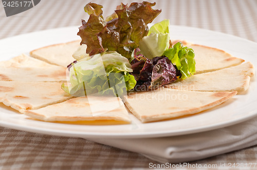 Image of garlic pita bread pizza with salad on top