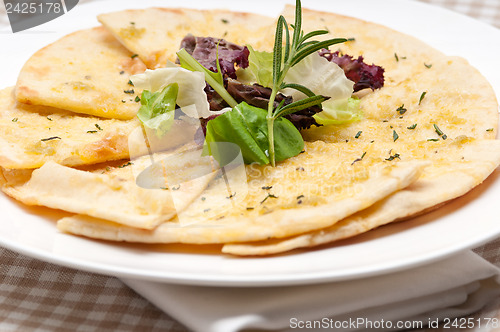 Image of garlic pita bread pizza with salad on top