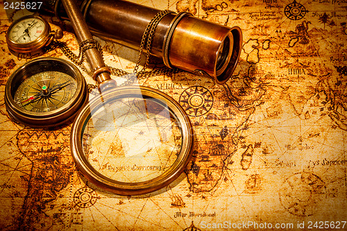 Image of Vintage magnifying glass lies on an ancient world map