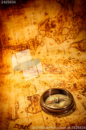 Image of Vintage compass lies on an ancient world map.