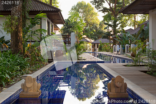 Image of pool with palm trees in an exotic hotel
