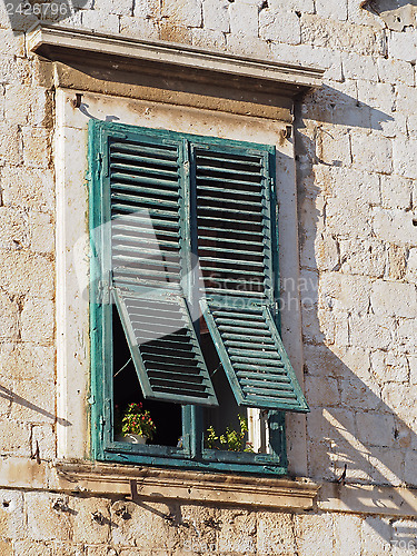 Image of old mediterranean window with green shutters