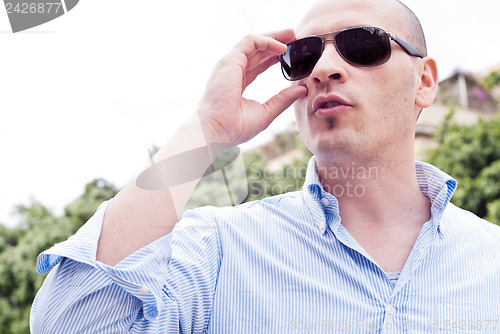 Image of portrait of a attractive gorgeous guy wearing sunglasses