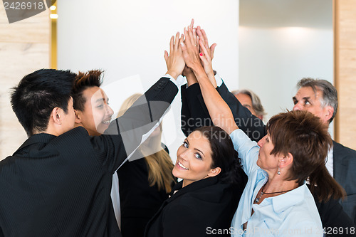 Image of Teamwork - business people with joint hands in the office