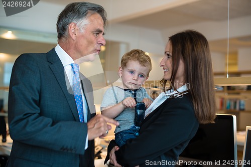 Image of Businesswoman with small child in the office
