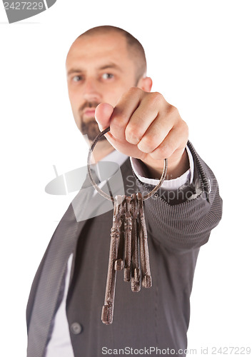 Image of Man in suit giving old keys to a house