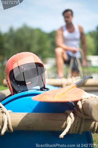 Image of Helmet and oar on inflatable raft