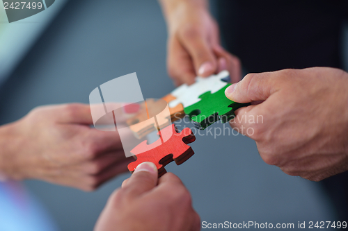 Image of Group of business people assembling jigsaw puzzle