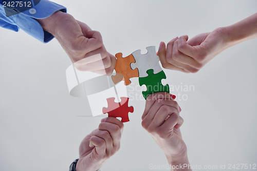 Image of Group of business people assembling jigsaw puzzle