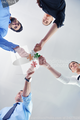 Image of Group of business people assembling jigsaw puzzle