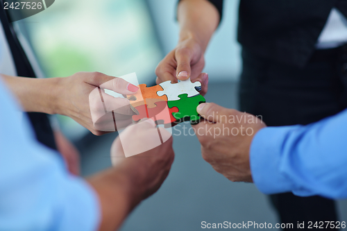 Image of Group of business people assembling jigsaw puzzle