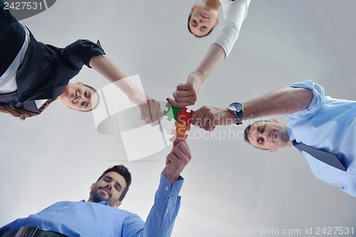 Image of Group of business people assembling jigsaw puzzle