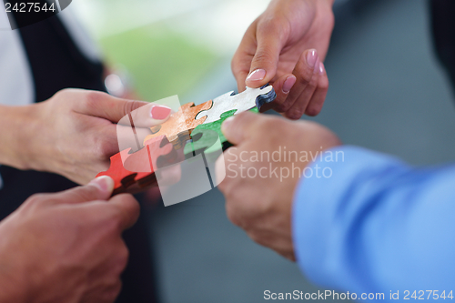 Image of Group of business people assembling jigsaw puzzle