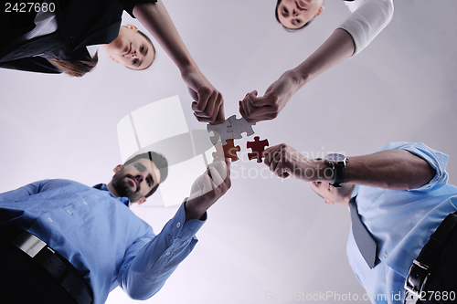 Image of Group of business people assembling jigsaw puzzle