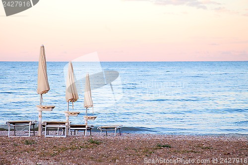 Image of closed umbrellas on evening beach
