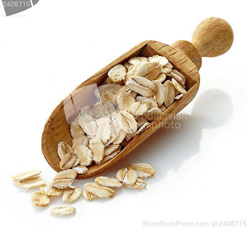 Image of wooden scoop with oat flakes