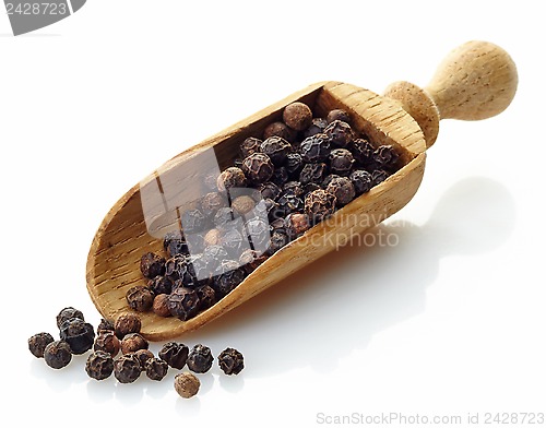 Image of wooden scoop with black peppers