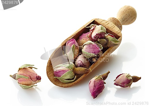 Image of wooden scoop with rose buds tea