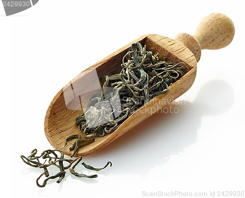 Image of wooden scoop with green tea