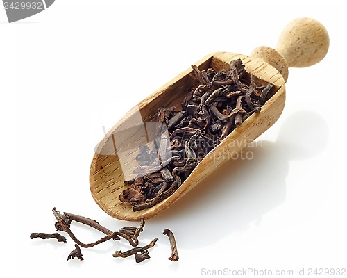 Image of wooden scoop with black tea Shu Puerh 