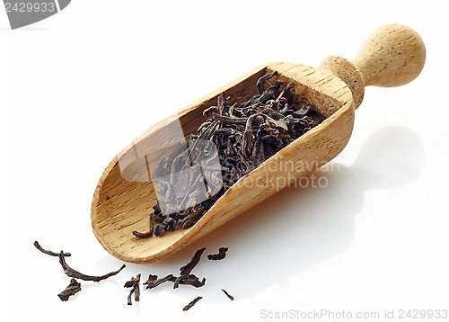 Image of wooden scoop with black tea Assam