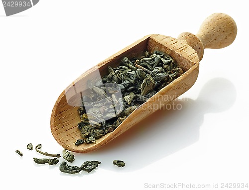 Image of wooden scoop with green tea camellia sinensis