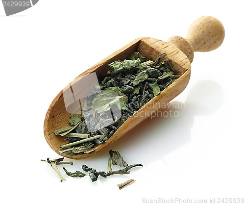 Image of wooden scoop with green tea and mint