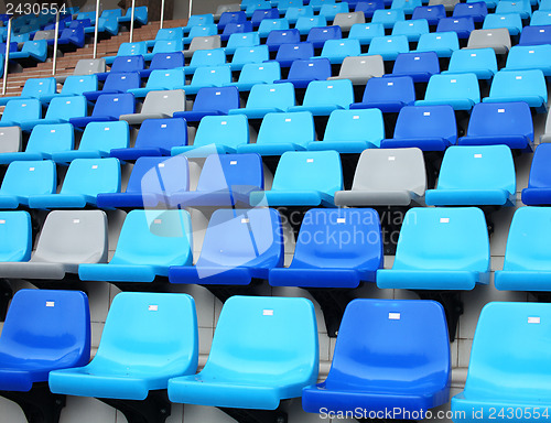 Image of blue plastic old stadium seats on concrete steps