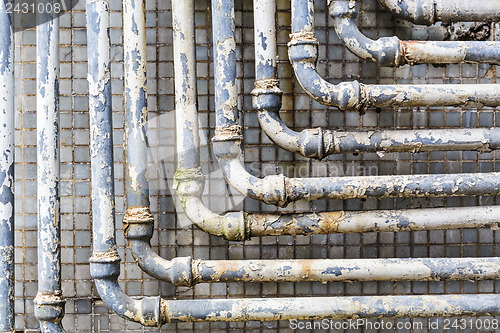 Image of Series of parallel old pipes on wall