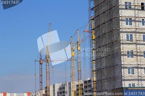 Image of Construction site with many cranes against the sky