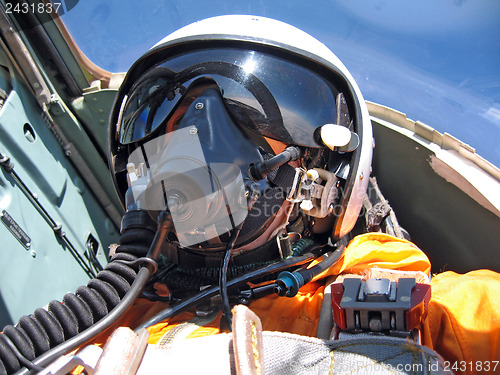 Image of military pilot in the plane in a helmet in dark blue overalls ag