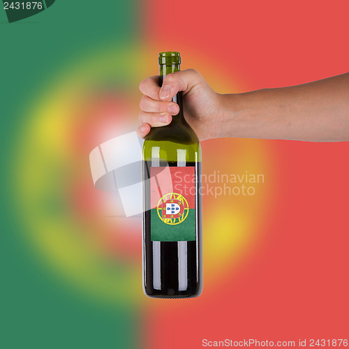 Image of Hand holding a bottle of red wine