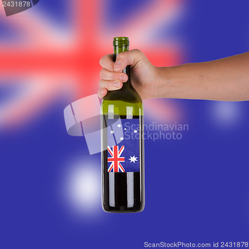 Image of Hand holding a bottle of red wine