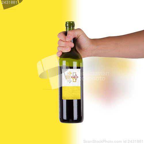 Image of Hand holding a bottle of red wine