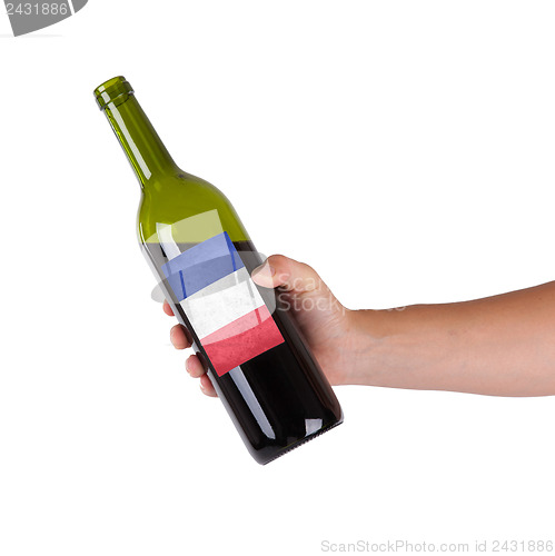 Image of Hand holding a bottle of red wine