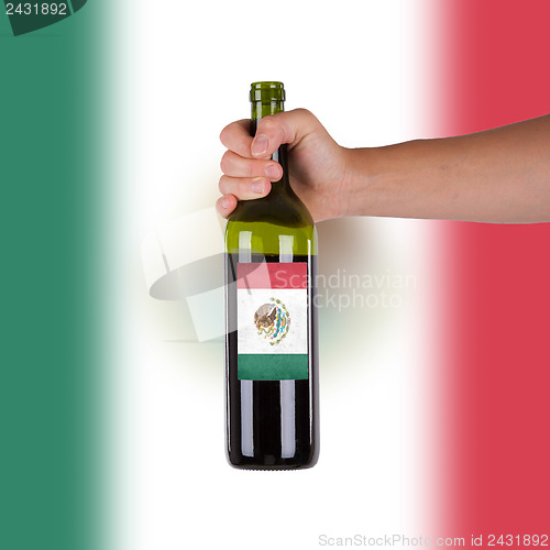 Image of Hand holding a bottle of red wine