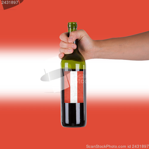 Image of Hand holding a bottle of red wine