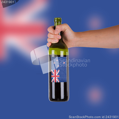 Image of Hand holding a bottle of red wine