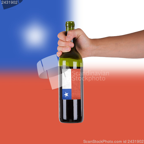 Image of Hand holding a bottle of red wine