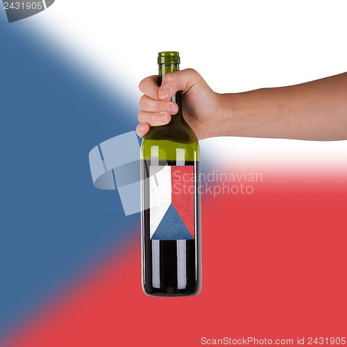 Image of Hand holding a bottle of red wine