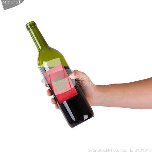 Image of Hand holding a bottle of red wine