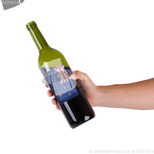 Image of Hand holding a bottle of red wine