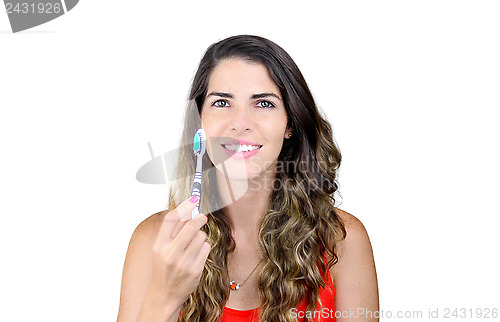 Image of Beautiful young woman showing toothbrush and smiling