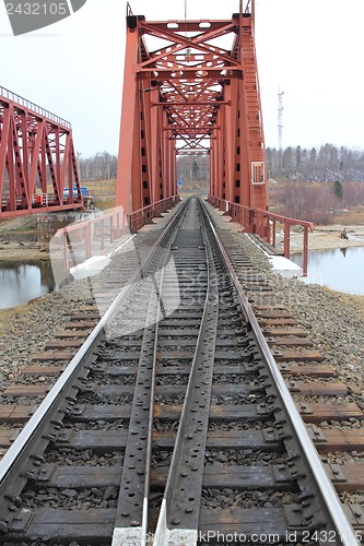 Image of Red metal railway bridge across the river.