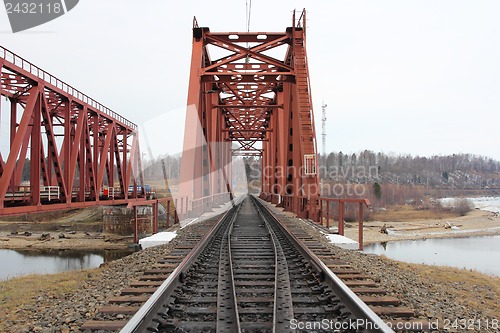 Image of Red metal railway bridge across the river.