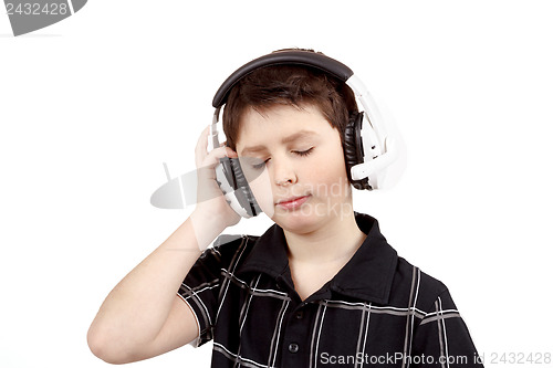 Image of Portrait of a happy young boy listening to music on headphones