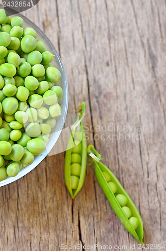 Image of Fresh green peas on an old wooden background