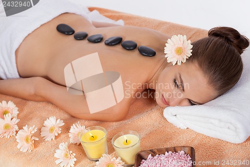 Image of attractive healthy caucasian woman hot stone massage wellness 